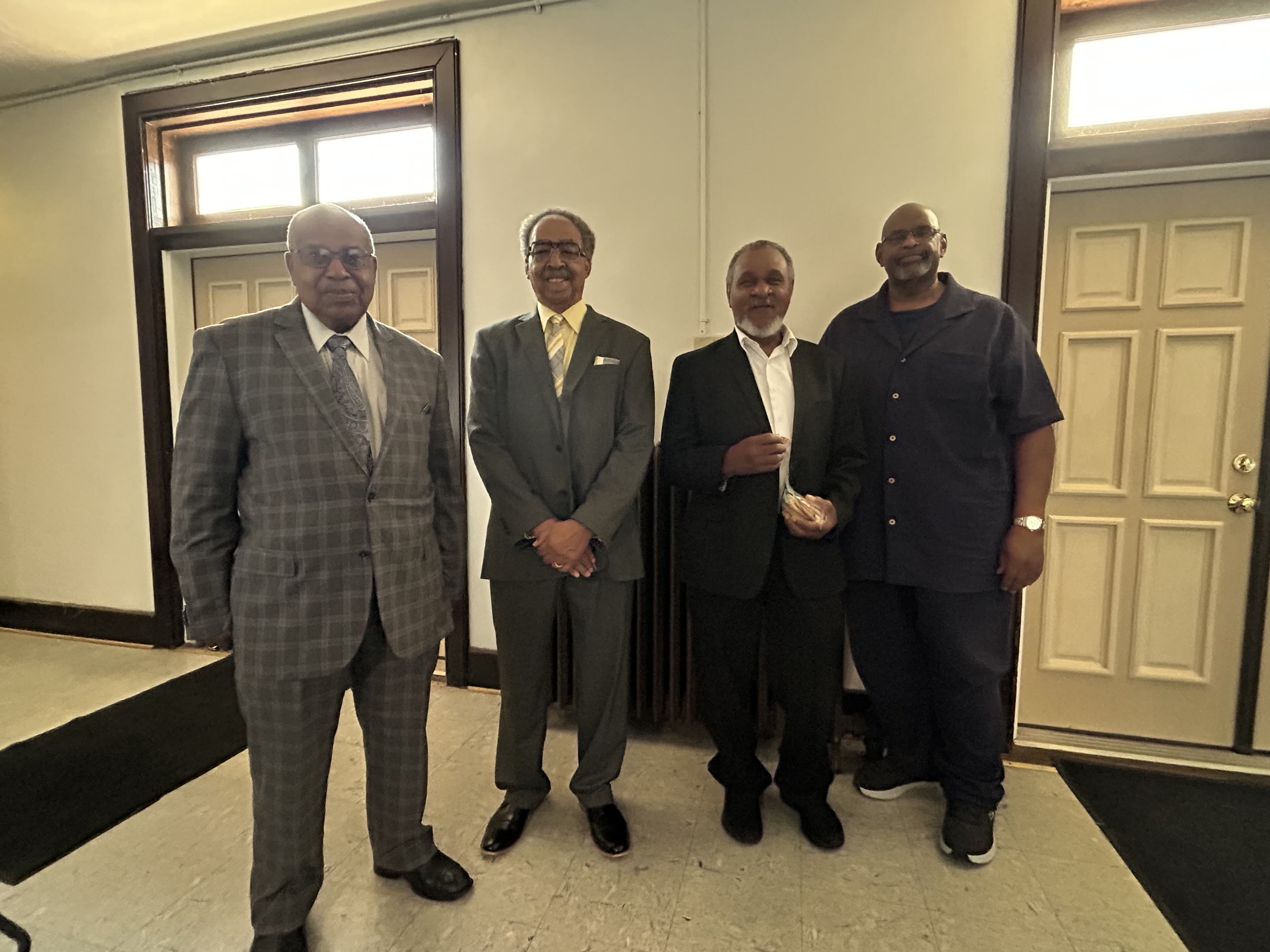 Four church brothers standing together in the church hall