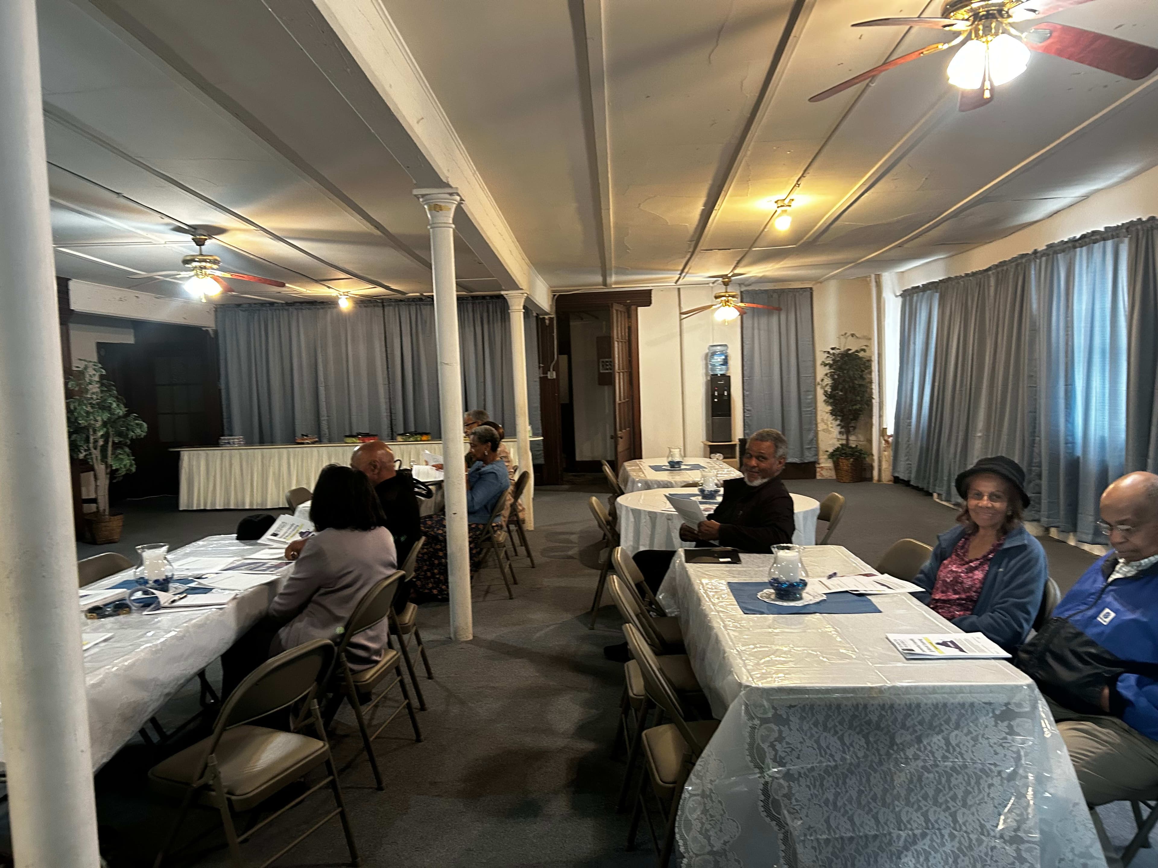 Attendees seated at tables in the church hall for the training