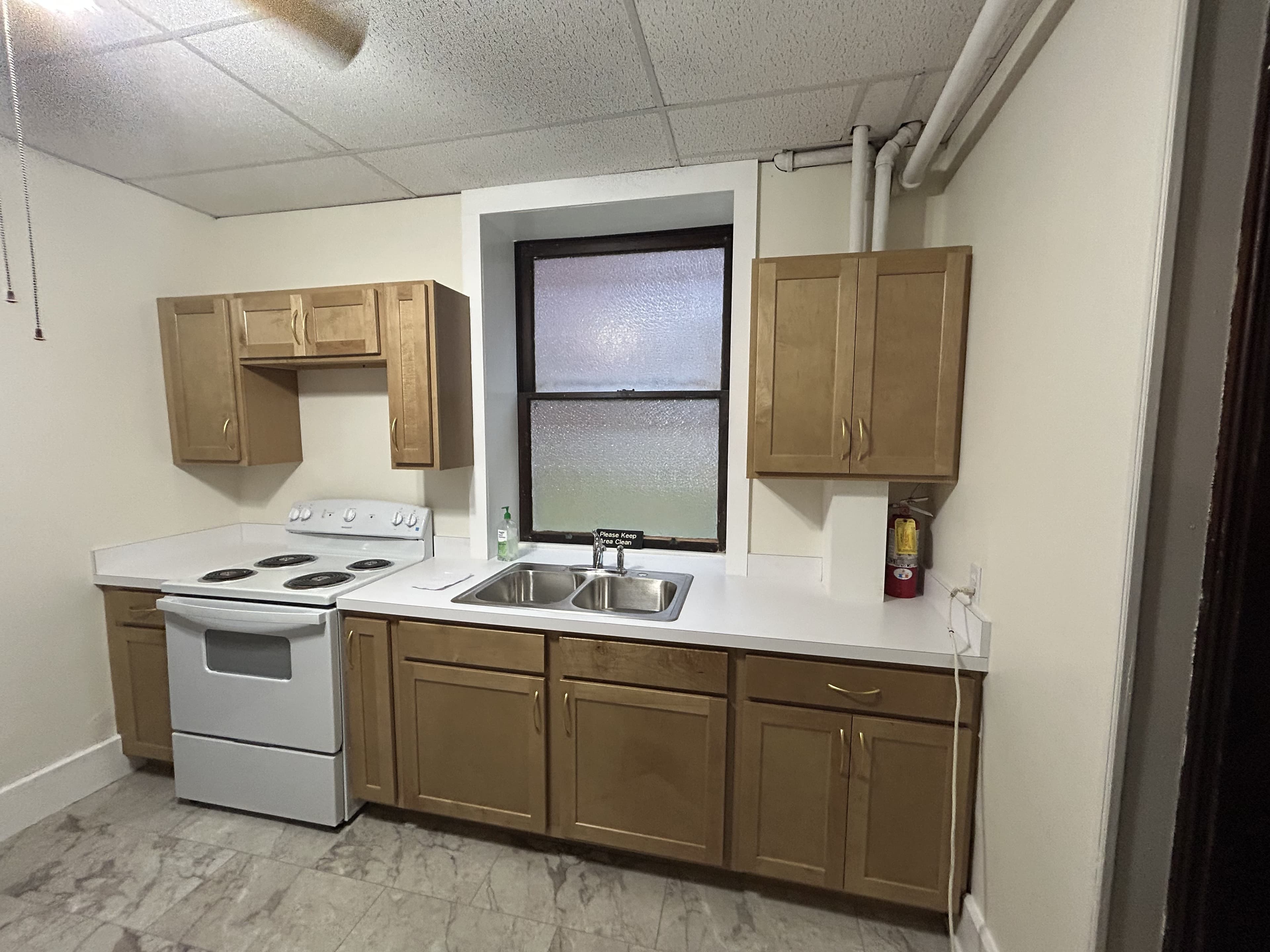 Renovated kitchen with new wood cabinets, countertop, and refrigerator