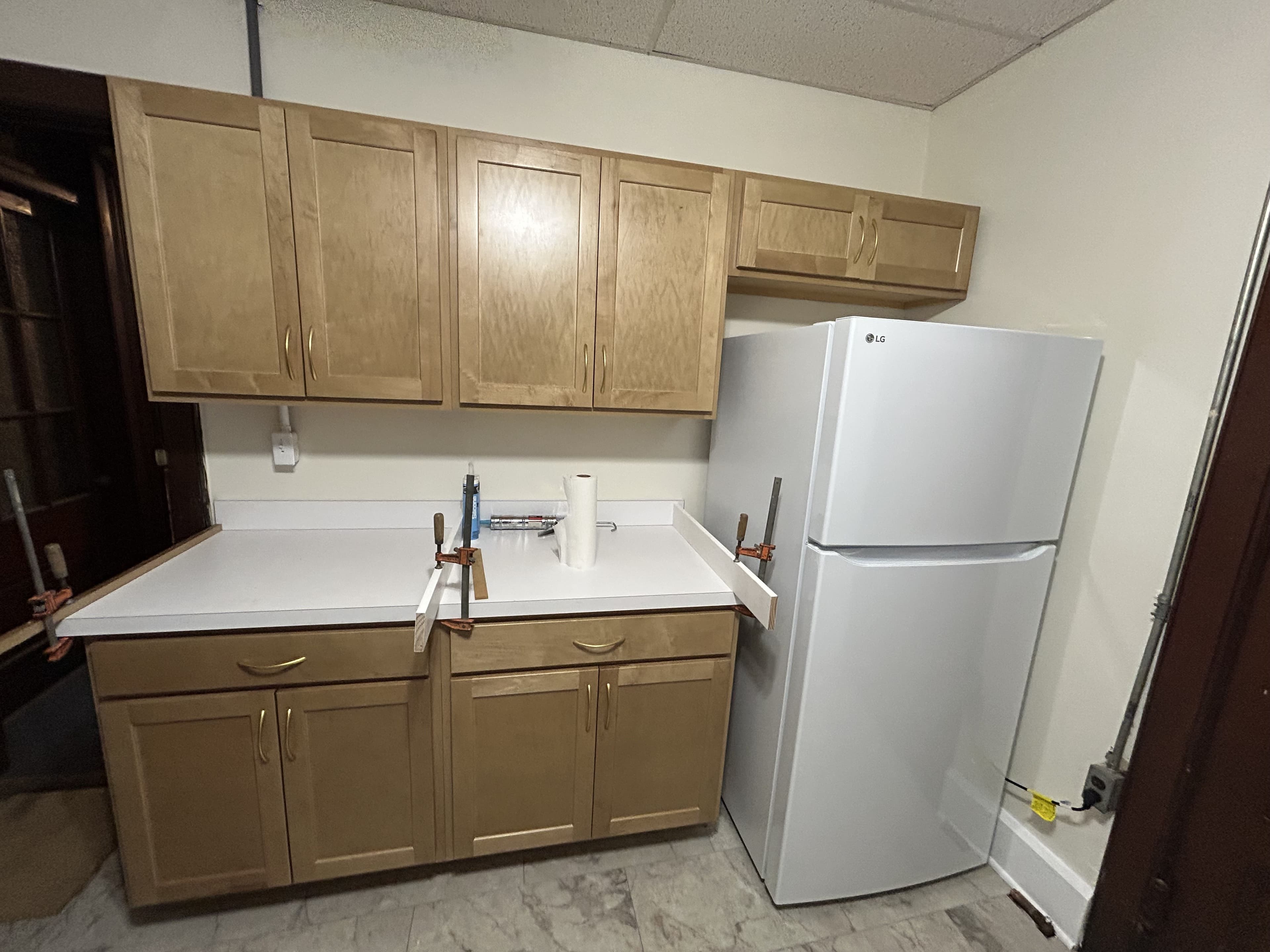 Renovated kitchen with new cabinets, sink, and stove beneath the window
